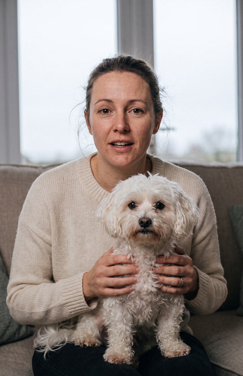 An owner on a sofa with her white maltese