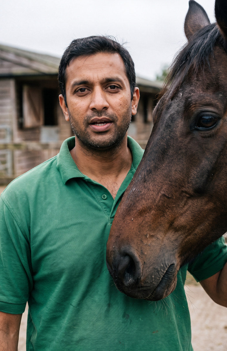 An equine veterinarian talking to camera beside a bay horse